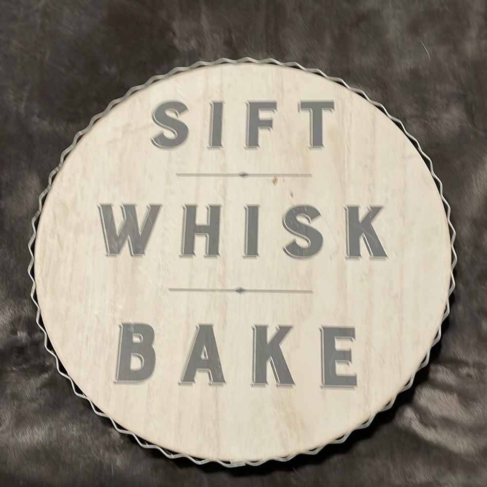 NWT’s- wooden round sign w/crinkled metal around wood. It says sift,whisk & bake